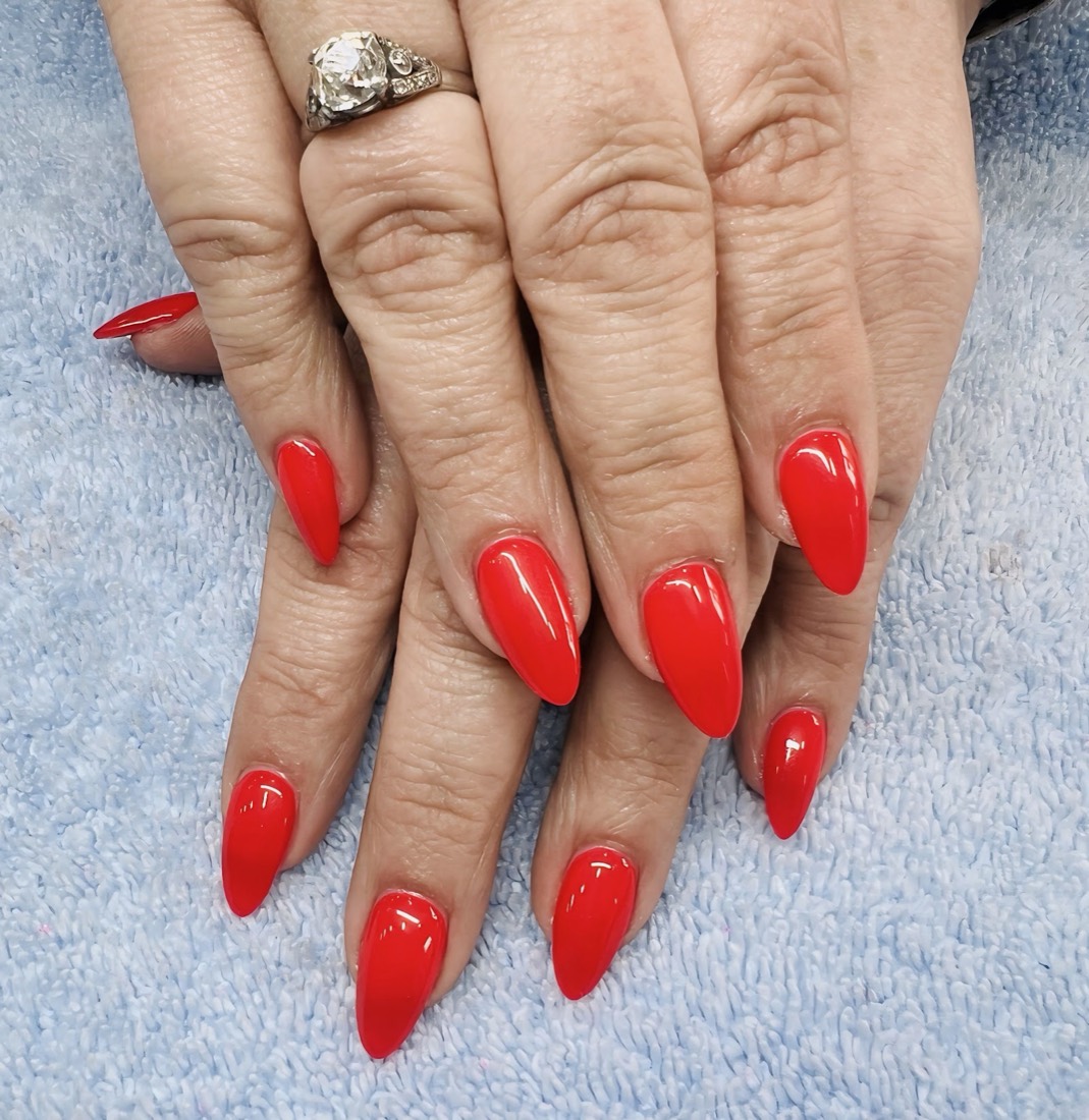 Glossy bright red almond-shaped gel nails
